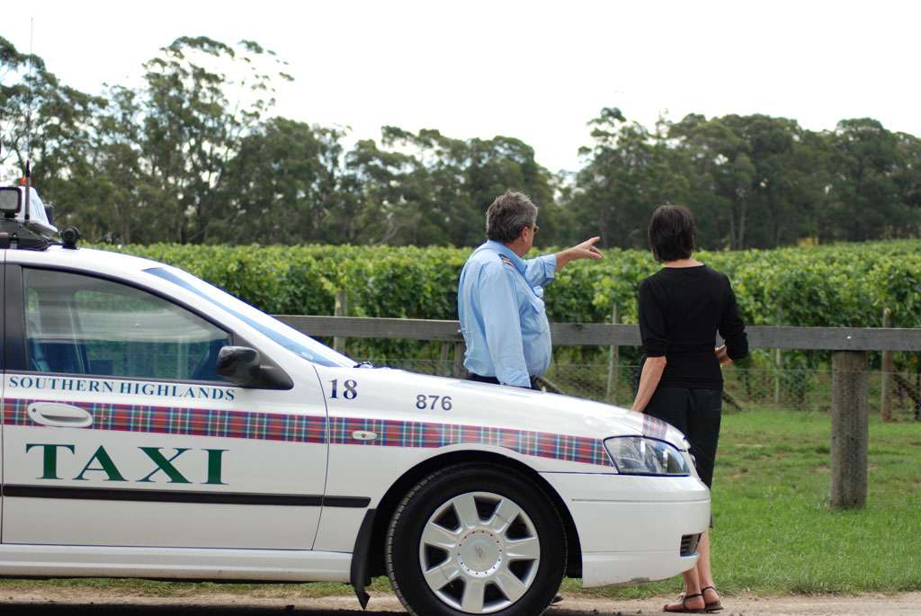 a man and woman standing next to a car