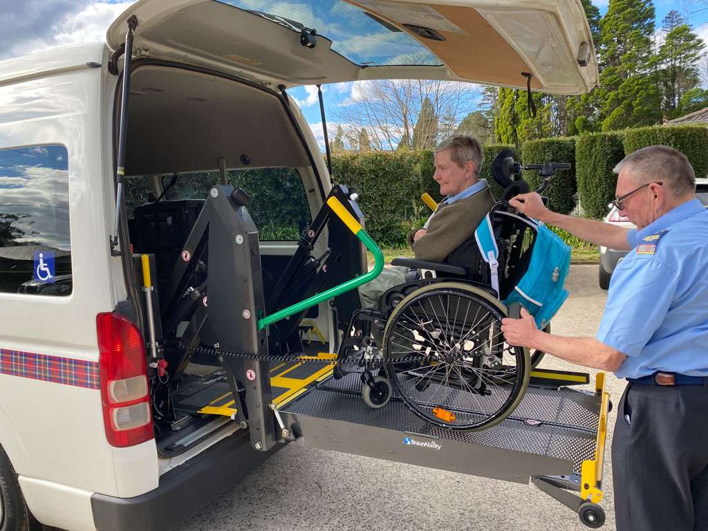 a man pushing a wheelchair in the back of a van