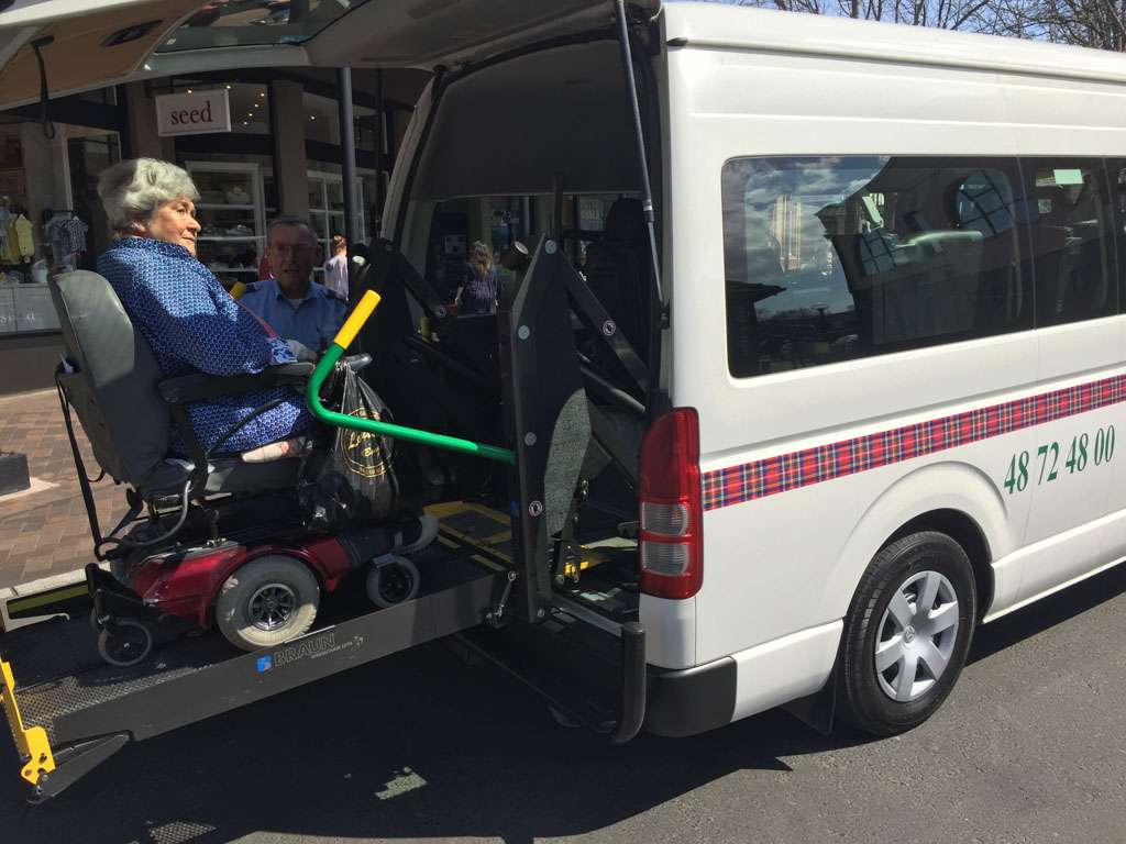 a woman in a wheelchair being loaded into a van